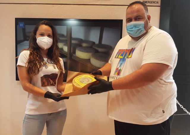 Yohana Mendoza del Cortijo de Pavón entrega el queso a Ricardo Güemez